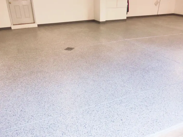 Beige flake floor finished up to the baseboards in an empty room