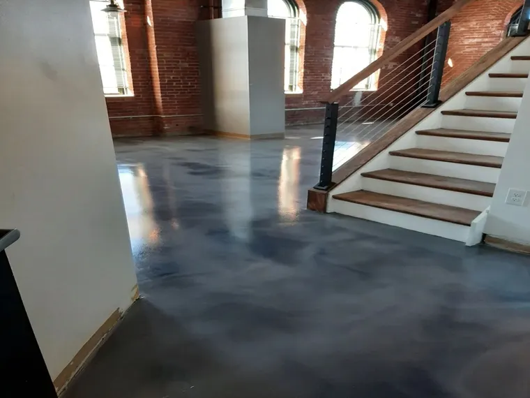 Blue gray metallic epoxy floor in a brick loft with an open staircase