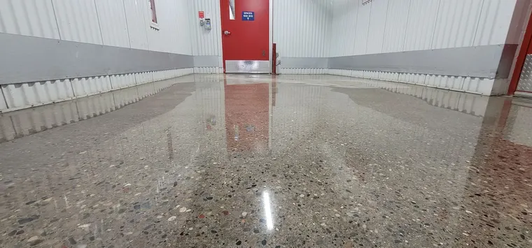 Polished concrete corridor reflecting the ceiling lights in a commercial building